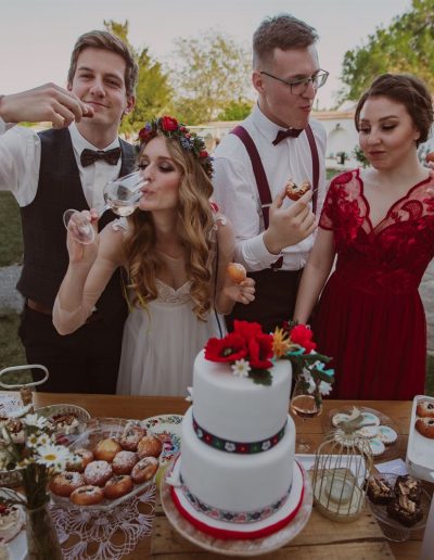 Focení svatebního editoriálu v Pouzdřanech u Brna na Ambrožově dvoře, kde je nevěsta, ženich a svědkové u stolu se sweetbarem, na kterém jsou dort, zákusky, koláčky.