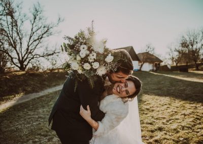 Svatební fotografie od svatební fotografky Fotky s duší pořízená ve skanzenu ve Strážnici na Slovácku v únoru, kde má nevěsta kožíšek. Ženich a nevěsta si užívají čas strávený spolu.